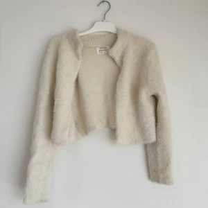 Beige fluffig kofta från Zara - Mysig och fluffig beige kofta från Zara Girls Winter Collection. Koftan är croppad med långa ärmar och har en mjuk, stickad känsla. Perfekt för kyliga dagar när du vill ha något bekvämt och stilrent. Passar S