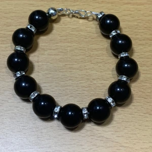Bracelet with black stone and clear rhinestones - This bracelet has black stones probably onyx. It is a bit heavy. Good condition.