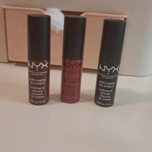 NYX Soft Matte Lip Cream minis - Tre olika nyanser av NYX Soft Matte Lip Cream. Färgerna är intensiva och matta, perfekt för en långvarig look. Förpackningarna är små och smidiga, lätta att ta med sig. Färgerna inkluderar en djup röd, en ljusare rosa och en mörk lila.