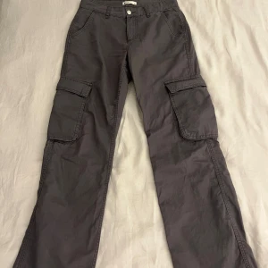 Grå cargos - Ett par helt oanvända grå cargos i lågmidjat. Fickor baktill, ganska loose nedtill. 