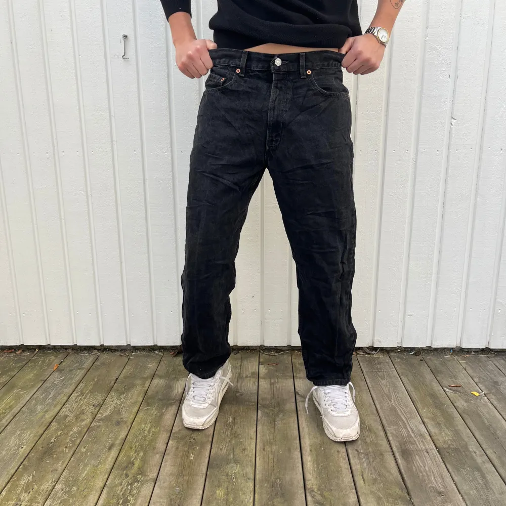 Säljer ett par svarta Levis 550 jeans i storlek 34. De har en loose passform och är perfekta för en avslappnad stil. Jeansen är i bra skick och har den klassiska Levis-loggan på baksidan. Perfekta för höst och vinter!. Jeans & Byxor.