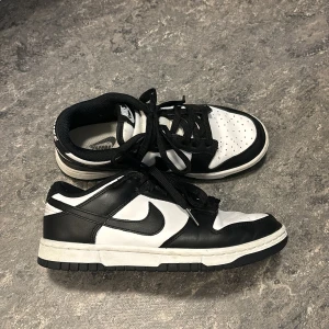 Nike Dunk Low skor - Ett par snygga och relativt nya Nike Dunk Low ”panda” skor i storleken 37,5. Skorna är väldigt bekväma och passar till många outfits. De har inte heller några skador.