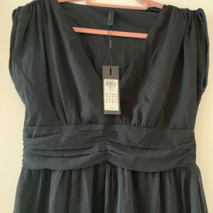 Oanvänd klänning från Vero Moda - Oanvänd klänning med fina detaljer. 88 längd från axel till nederkant 42 cm bröstmått  