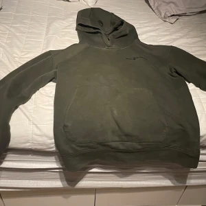 Grön hoodie från Sail racing - Säljer en grön hoodie från Sail racing i storlek 176. Den är perfekt för kyliga dagar med sin mysiga huva och stora ficka framtill. Tröjan är i bra skick och passar både till vardags och chillkvällar. Skön och stilren design som funkar till det mesta. Hör av dig vid intresse!