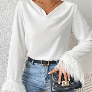 Vit blus med fjäderdetaljer - Säljer en elegant vit blus med fjäderdetaljer vid ärmsluten. Jag har bara använt den en gång, så den är i princip ny och i mycket bra skick.