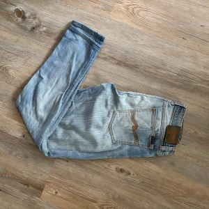 Nudie jeans  - Ett par nudie jeans som är i ett helt okej skick därav priset. Det finns en liten defekt som ni ser på  bild 4, det är en väldigt  liten slitning men ändå värt att säga. annars väldigt snygga och fräscha jeans i storlek 31-34 så passar de flesta.💫👍