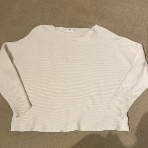 Vit ribbad tröja från MANGO - Säljer en stilren vit ribbad tröja från MANGO. Den har en avslappnad passform med långa ärmar och är perfekt för både vardag och mysiga hemmakvällar. Tröjan är i bra skick och passar till alla säsonger. Perfekt basplagg i garderoben! 🤍