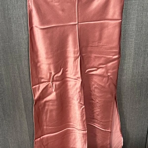 Rosa satin långkjol - Säljer en superfin rosa långkjol i satin. Den har en elegant glans och är perfekt för festliga tillfällen. Kjolen är i nyskick och har en smickrande passform. Perfekt för att glamma upp din garderob! 💖