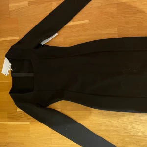 Medellång svart klänning - Aldrig använd med lapp kvar, den är väldigt figursydd med en fyrkantig urringning och slits i armarna