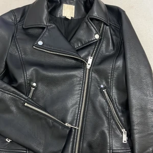 Svart skinnjacka med dragkedjor - Säljer en snygg svart skinnjacka i nyskick i st 36 från H&m!  Perfekt för höst och vår, och funkar lika bra till fest som till vardags. Jackan har långa ärmar och en normal passform. Priset går att diskutera :)