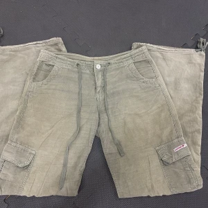 Lågmidjade cargobyxor - Så coola lågmidjade cargobyxor i manchestermaterial. Midjemått 38 cm raktöver och 73 i innerbenet. Lite slitna vid lappen i bak, syns på bild.  Skriv vid frågor☺️