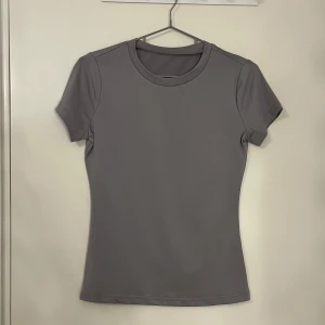 Grå t-shirt - Snygg grå t-shirt med rund hals och korta ärmar. Perfekt för en stilren och enkel look. Passar bra till både jeans och shorts.