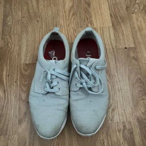 Grå sneakers från Björn Borg - Säljer ett par grå sneakers från Björn Borg med snörning och vit sula. Skorna har en stilren design med ljusgrått tyg och vita detaljer på hälen. Perfekta för en avslappnad stil.