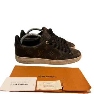  Louis Vuitton skor - Snygga bruna sneakers från Louis Vuitton med det ikoniska monogrammönstret. Skorna har en klassisk design med snörning och en vit sula. Perfekta för den som vill ha en stilren och lyxig look. Mvh scandicfashion 💯