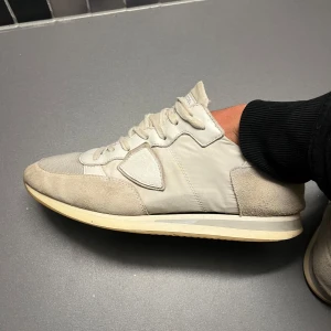 Beige sneakers med mockadetaljer - Snygga beige sneakers med snörning och mockadetaljer. Perfekta för en stilren look. Skorna har en klassisk design med en bekväm sula.