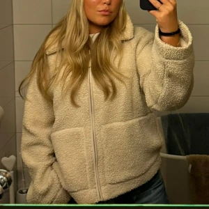 Beige teddyjacka - Mysig beige teddyjacka med dragkedja framtill från hm Jackan har långa ärmar och en avslappnad passform, storlek L i fint skick