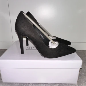 Svarta pumps från New Look - Eleganta svarta pumps från NLY Shoes med spetsig tå och hög klack. Perfekta för en stilren look. Tillverkade i syntetmaterial för en klassisk finish.