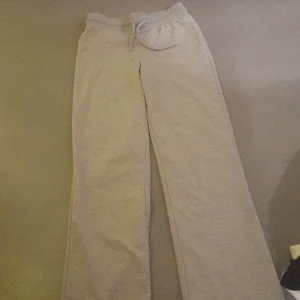 Grå mjukisbyxor från 157 - Säljer ett par bekväma grå mjukisbyxor från 157. De har en elastisk midja med snörning för justerbar passform. Perfekta för en avslappnad stil.