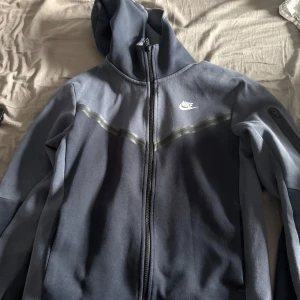 Mörkblå nike tech hoodie - Säljer en mörkblå Nike tech storlek M tröjan har använts lite mer men väldigt varsamt 