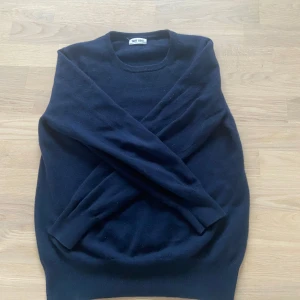 Mörkblå kashmirtröja från Soft Goat - Säljer en elegant mörkblå kashmirtröja från Soft Goat. Tröjan har en klassisk rund hals och långa ärmar, perfekt för en stilig look. Den är mjuk och bekväm, vilket gör den till ett stilrent tillskott i garderoben. Storlek S, väldigt bra skick
