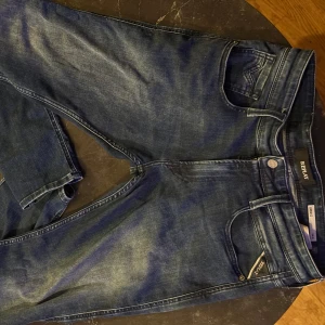 Blå jeans från Replay - Helt nya, bara använde 1 eller 2 gånger. Snygga blå jeans från Replay med klassisk femficksdesign och knappgylf. De har en modern passform och är perfekta för en avslappnad stil. Märkesdetaljer syns på bakfickan och linningen. För fler bilder är det bara och skriva!