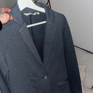 Mörkgrå kavaj - Stilig kavaj använd en gång , tunn och sätter sig tight så kurvorna syns. Stilrent och använd två gånger.