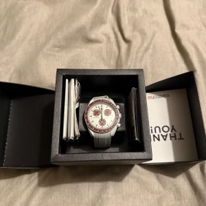 Omega Swatch klocka - Säljer denna skitsnygga och trendiga omega swatch mission to pluto som är helt ny! Vid köp ingår box, samt ett extra armband som passar jättebra med den röda länken! Storlek på klockan kan justeras. Skicket är jättebra och det finns inga defekter. 