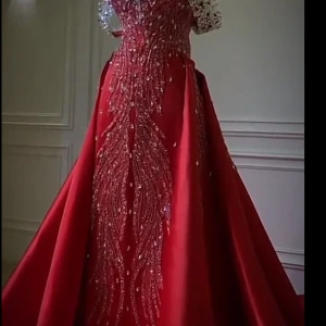 Röd långklänning med pärlor - Elegant röd långklänning med detaljerade pärlor och paljetter som ger en glittrig effekt. Klänningen har en vacker passform och är perfekt för festliga tillfällen. Den har en lång kjol som ger en dramatisk look.