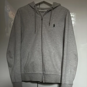 Grå hoodie från Ralph Lauren - Säljer en stilren grå hoodie från Ralph Lauren. Oerhört bra skick. Inga defekter och till schysst pris då en sån här tröja är svår att få tag i och kostar runt 2000kr ny. St: S