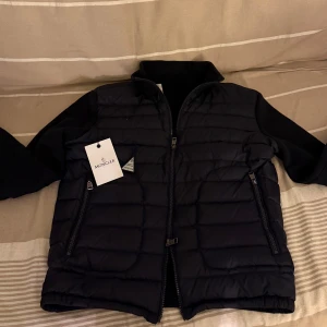 Mörkblå cardigan  från Moncler - Snygg mörkblå cardigan från Moncler med dragkedja och långa ärmar. Jackan har en quiltad design och är perfekt för kyligare väder. Den har en stilren look med två praktiska fickor framtill. Jag på bilden är 171 och jackan är på gränsen till för liten. Kom privat om du har några funderingar! 🔥😎