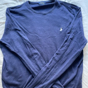 Mörkblå tröja från Ralph Lauren - Säljer en stilren mörkblå tröja från Ralph Lauren som passar riktigt bra inför våren och sommaren. Tröjan är i storlek L men passar garanterat M. Tröjan är inte använd särskilt mycket men har ändå hängt i garderoben ett tag. Därför är skicket 8/10 och därav det bra priset.