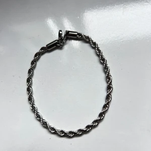 Silverfärgat tvinnat armband - Snyggt silverfärgat armband med en tvinnad design. Perfekt för att ge en stilren touch till din outfit. Armbandet har en enkel låsmekanism som gör det lätt att ta på och av. Jag skickar produkten samma eller nästa dag❤️