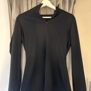 Svart långärmad tröja från Shein - Säljer en stilren svart långärmad tröja från Shein. Tröjan har en dragkedja vid halsen och är perfekt för en casual look. Den är tillverkad i ett mjukt och bekvämt material som passar bra till när man ska träna.