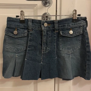 Mini kjol - Snygg blå jeanskjol från Crash med veckade detaljer och fickor fram. Storlek XS eller S, barn storlek 170. 