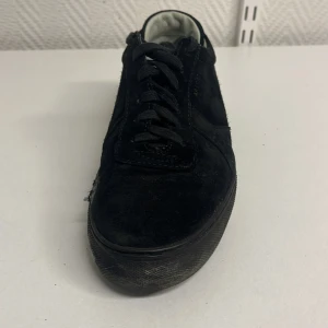 Svarta sneakers från Axel Arigato - Snygga svarta sneakers i mocka från Axel Arigato med klassisk design och snörning. Skorna har en diskret logga på sidan och en robust sula för extra komfort. Perfekta för en stilren look.