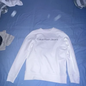 Vit tröja från Calvin Klein Jeans - Säljer en stilren vit tröja från Calvin Klein. Hör av er vid minsta fråga eller fundering. Pris kan diskuteras