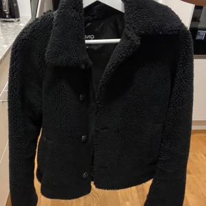 teddy jacka  - använd, men i gott skick! kommer rolla jackan innan postning och kan va lite trådar här och var men inget som är märkvärdigt men för att förstå vad jag menar se bild 4. lite skinnimitation under kragen, knapparna ser ut som sköldpaddsknappar, superfin! 