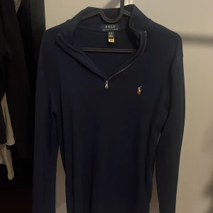 Mörkblå half zip från Ralph Lauren - Säljer en stilren mörkblå half zip från Ralph Lauren. Den är i mycket bra skick och passar S, kan även passa M. Tröjan passar perfekt till en avslappnad och elegant look. Hör av er vid minsta fundering. 