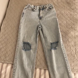 Ljusa jeans med slitna knän - Snygga ljusa jeans med slitna detaljer på knäna. De har en klassisk femficksdesign och en rak passform. Perfekta för en avslappnad stil.