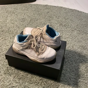 Vita jordans med baby blue inuti skon  - Säljer ett par vita Nike Air Jordans med blå insida. Skorna har snörning och en perforerad design på sidorna. De kommer i originalkartong med den ikoniska Jumpman-loggan.Dom säljs inte längre så dom är väldigt ovanliga.