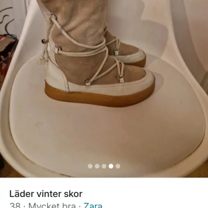 Beige vinterstövlar från Zara - Säljer ett par snygga beige vinterstövlar från Zara. De har en robust sula och dekorativa snörningar. Perfekta för kalla dagar.I äkta läder.