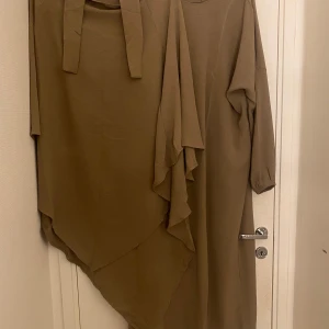  Abaya och khimar - Säljer min oanvända abaya och khimar från SHEIN. Kan fota fler bilder om det önskas. Khimaren ser lite lång på bilden men när man väl tar på sig den är den jätte fin. Färgen är beige brun eller mörk beige.Vi fler frågor skrin på dm 😊