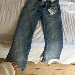 Blå jeans från BDG - Snygga blå jeans från BDG med en klassisk femficksdesign och dragkedja. Jeansen har en avslappnad passform och är perfekta för en casual look. Märket BDG är känt för sin stilrena design och hållbara material.
