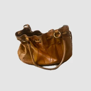 Vintage väska i skinn - Snygg brun axelväska i skinn från Wera. Väskan är stor och praktisk med plats för en dator, den går inte att stänga men jag skulle inte säga att det gör nått💗💗