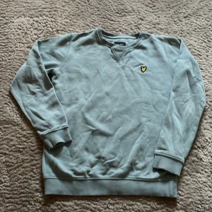 Grön sweatshirt från Lyle & Scott Junior - Säljer en stilren grön sweatshirt från Lyle & Scott Junior. Tröjan har långa ärmar och en ribbad kant vid ärmslut och nederkant. Perfekt för en avslappnad stil. 🐥