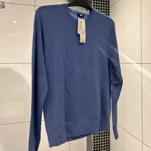 Blå tröja i merinoull från Uniqlo - Säljer en stilren blå tröja från Uniqlo i extra fin merinoull. Den är maskintvättbar vilket gör den både praktisk och bekväm. Tröjan är helt oanvänd då den inte har kommit till användning! Om du har fler frågor eller funderingar så ska du inte tveka på att kontakta⭐️