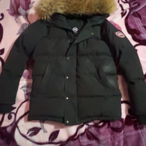 Svart Canada Goose jacka - Säljer en svart Canada Goose jacka med päls på huvan. Jackan har långa ärmar och stängs med dragkedja och knappar. Perfekt för kalla dagar jackan behöver lite tvätt priset går att diskuteras 