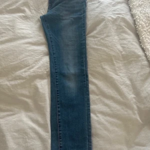 Blå jeansbyxor från The Rocker - Snygga blå jeansbyxor från The Rocker med en klassisk design. De har en knapp och dragkedja framtill samt en ficka bak. Perfekta för en avslappnad stil.