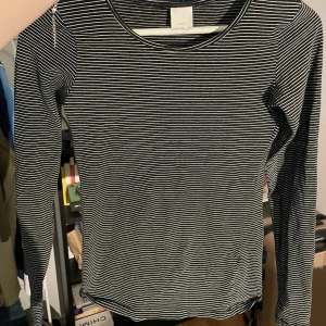 Svart och vit randig långärmad topp - Säljer en stilren svart och vit randig långärmad topp från H&M i storlek s. Använd ett fåtal gånger. Hör av dig vid intresse!