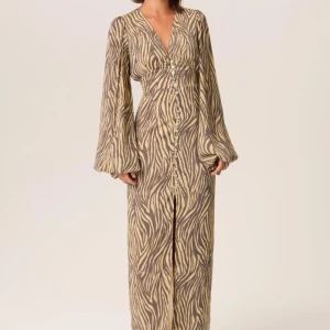 Långklänning från Adoore  - Trendig långklänning med zebramönster från Adoore. Klänningen har långa ärmar och knappar framtill samt en slits som ger en elegant touch. Säljer klänningen då den inte kommit tillanvändinge då den endast är använd under 3 tillfällen ❤️